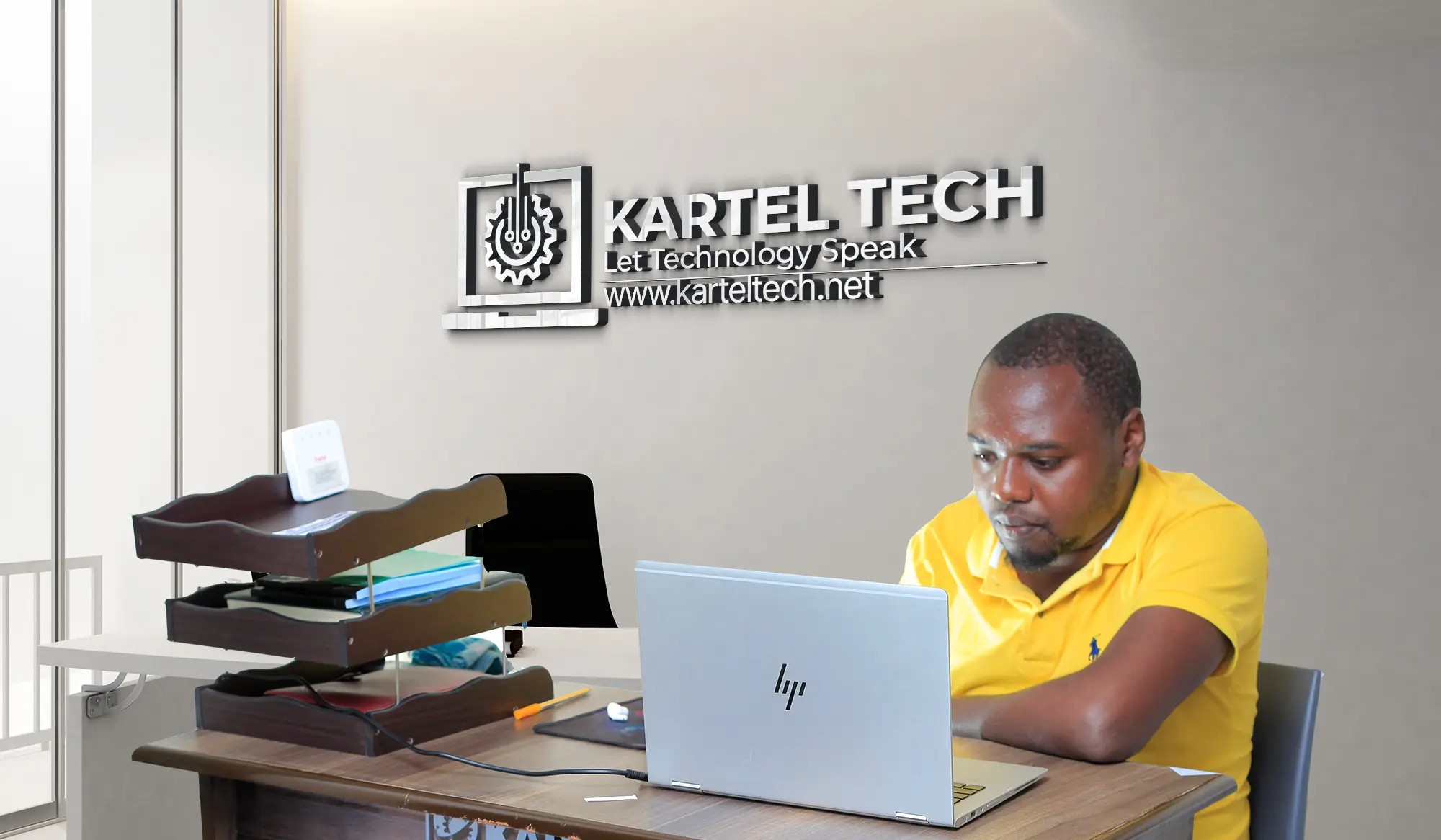 Kartel Tech founder working diligently on a laptop in a modern office, showcasing dedication to technology.